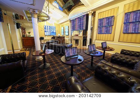 Tables with gaming computers and lot of screens in bookmaker office of casino, my photo on screens