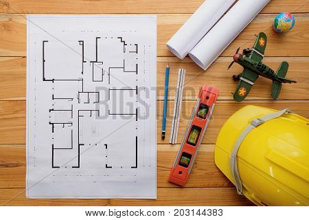 Architect desk project in construction site with blueprintpen hardhat and construction level.Top view with copy space.