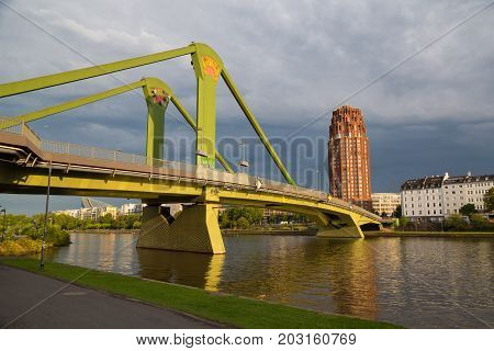 Bridge Floesser across the river Main at sunset. View from the embankment. Frankfurt am Main city. Germany