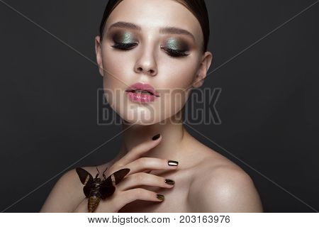 Portrait of beautiful girl with colorful make-up and cicada. Beauty face. Photo taken in the studio.