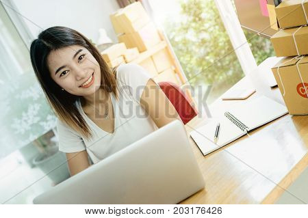 Young asian girl is freelancer with her private business at home office working with laptop coffee online marketing Customer order and packaging or packing.