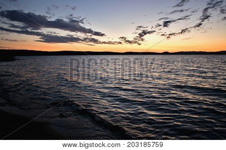 dark Cirrus clouds at sunset over the lake, South Ural, Uvildy