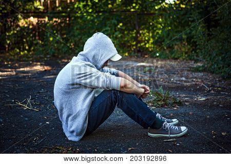 Sad Teenager sit on the Ground outdoor