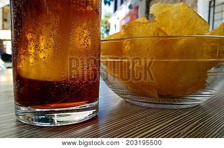 Cola drink and potato chips on a sunny morning