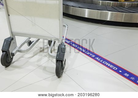 Sign of "No trolley beyond this line" in the airport luggage drop area