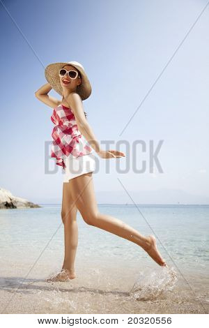jeune femme en tenue rétro, sauter partout sur la plage