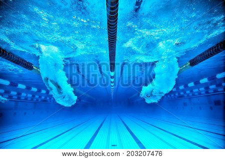 two peaple are leaping in a pool
