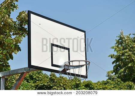 Basketball hoop outdoor with trees and sky