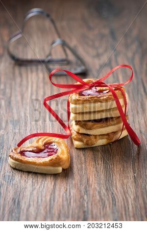 A pile of cookies with jam on a wooden rustic table.