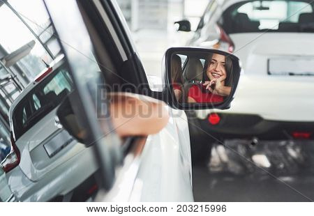 woman in car indoor keeps wheel turning around smiling looking at passengers in back seat idea taxi driver against sunset rays Light shine sky Concept of exam Vehicle - second home the girl.