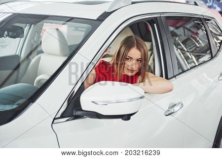 woman in car indoor keeps wheel turning around smiling looking at passengers in back seat idea taxi driver against sunset rays Light shine sky Concept of exam Vehicle - second home the girl.