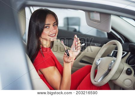 woman in car indoor keeps wheel turning around smiling looking at passengers in back seat idea taxi driver against sunset rays Light shine sky Concept of exam Vehicle - second home the girl.