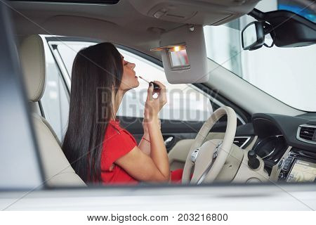 woman in car indoor keeps wheel turning around smiling looking at passengers in back seat idea taxi driver against sunset rays Light shine sky Concept of exam Vehicle - second home the girl.