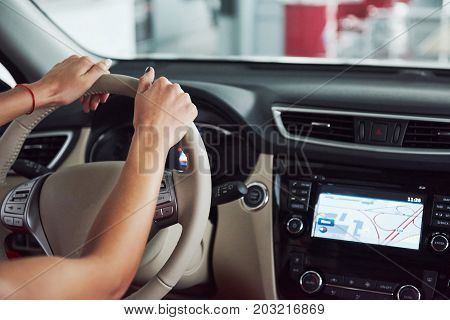 woman in car indoor keeps wheel turning around smiling looking at passengers in back seat idea taxi driver against sunset rays Light shine sky Concept of exam Vehicle - second home the girl.