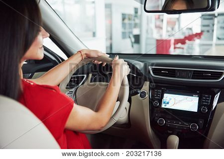 woman in car indoor keeps wheel turning around smiling looking at passengers in back seat idea taxi driver against sunset rays Light shine sky Concept of exam Vehicle - second home the girl.