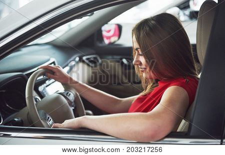 woman in car indoor keeps wheel turning around smiling looking at passengers in back seat idea taxi driver against sunset rays Light shine sky Concept of exam Vehicle - second home the girl.