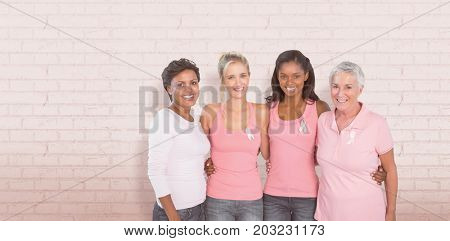 Portrait of happy women supporting breast cancer social issue against white wall 