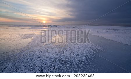 cold winter morning on the lake / the glimpses of sunlight through a cloudy sky