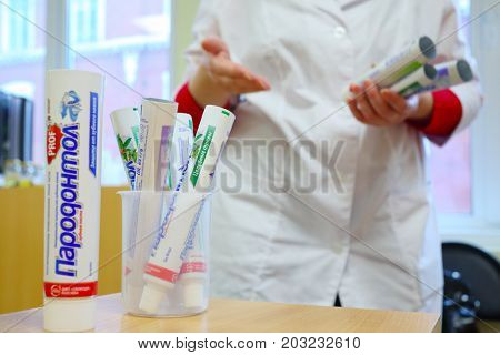 MOSCOW - SEP 15, 2016: Female hands showing toothpaste Parodontol in cosmetics factory Freedom was created on basis of first in Russia perfume factory Rally and Co, which was founded in 1843