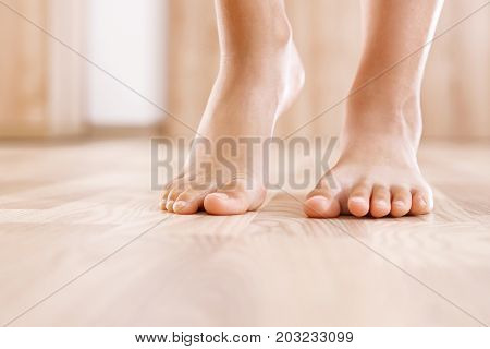 Healthy foot baby.
Feet of baby's naked against the background of the wooden floor
