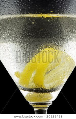 검은 바탕에 유리의 표면에 결로와 레몬 트위스트 마티니의 근접 촬영