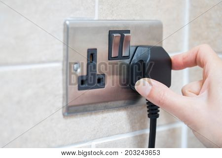 Close Up Of Hand Putting Plug Into Electricity Socket