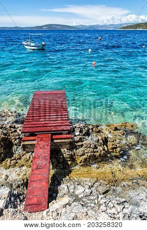 Beautiful Mediterranean sea Solta Croatia. Summer vacation. Springboard turquoise water and little boat.