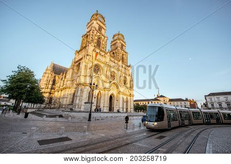 Street view on the saint Croix cathedral with tram in Orleans city during the sunset in central France