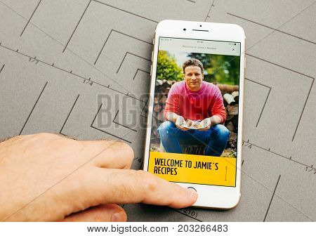 PARIS FRANCE - SEP 26 2016: Male hand holding New Apple iPhone 7 Plus after unboxing and testing by installing the app application software food app by Jamie Oliver