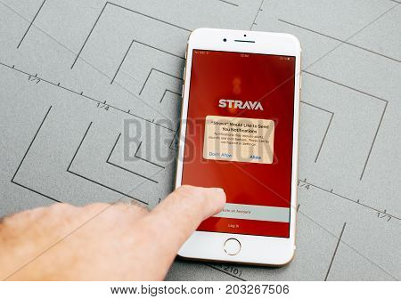 PARIS FRANCE - SEP 26 2016: Male hand holding New Apple iPhone 7 Plus after unboxing and testing by installing the app application software strava tracking sport app
