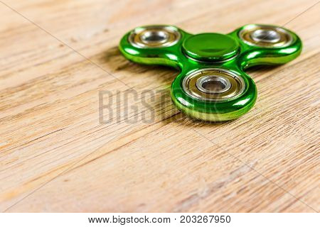 Spinner fidget toy for stress relieving on wood table background with copy space for your creative design project.