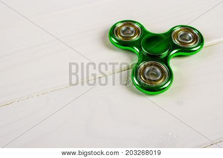 Spinner fidget toy for stress relieving on wood table background with copy space for your creative design project.