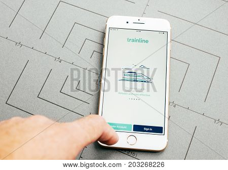 PARIS FRANCE - SEP 26 2016: Male hand holding New Apple iPhone 7 Plus after unboxing and testing by installing the app application software Trainline app to buy train tickets