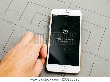 PARIS FRANCE - SEP 26 2016: Male hand holding New Apple iPhone 7 Plus after unboxing and testing by installing the app application software Adobe software app sign-in