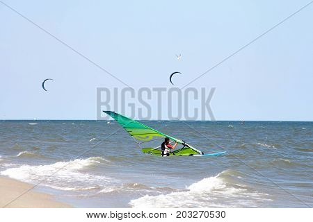 Windserfer learns beach start element with sail at sea ocean with free space