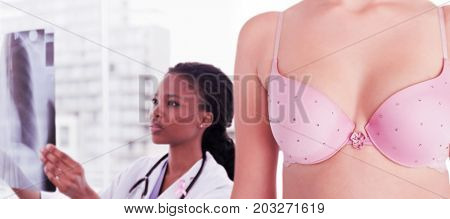 Composite image of mid section of woman wearing pink bra for breast cancer social issue