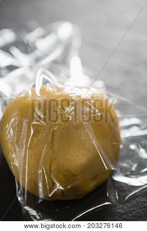 High anlge view of dough in plastic wrap on table