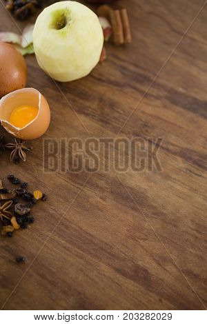 High anlge view of apple with egg and spices on wooden table