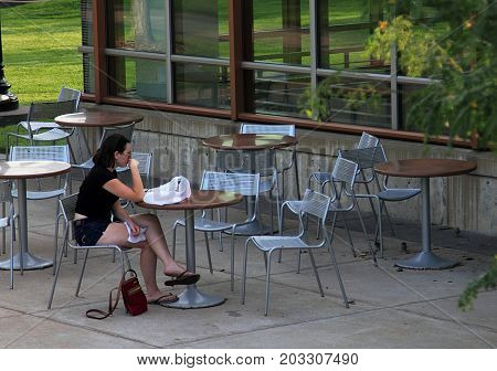 Minneapolis, Minnesota - July 8, 2015: Young girl in abandoned street cafe of University of Minnesota campus.