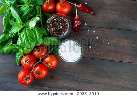 Tomatoes And Bunch Of Fresh Green Basil On A Dark Wood Background,