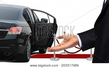 Driver standing with welcome gesture next to limousine