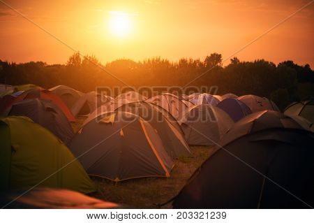 tent town at a festival in the rays of the setting sun