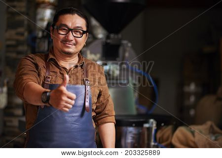 Cheerful roastery owner in glasses showing thumbs-up