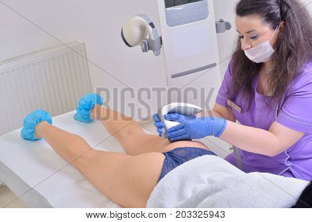 Young beautiful woman gets professional body shape treatment in a beauty clinic