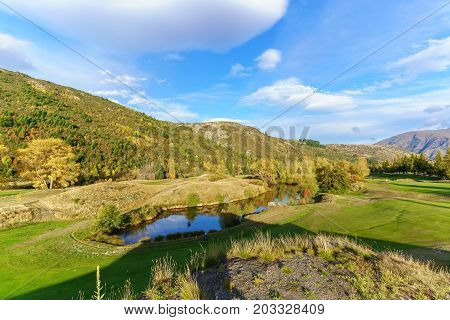 Female golfer is playing on Arrowtown Golf course in Autumn South Island of New Zealand