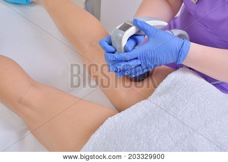 Young beautiful woman gets professional body shape treatment in a beauty clinic