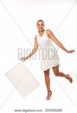 Young jocular woman portrait of a confident businesswoman showing presentation, pointing placard gray background. Ideal for banners, registration forms, presentation, landings, presenting concept.