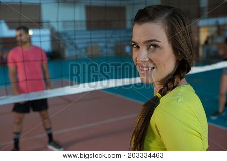 Portrait of smiling female volleyball player with braided hair at court