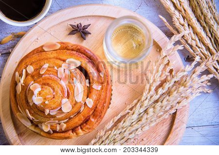 Fresh tasty bread with coffee and honey bee with milk on the table.