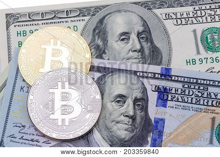 Closeup of golden  and silver bitcoin on hundred dollars banknote, macro shot. High resolution photo.